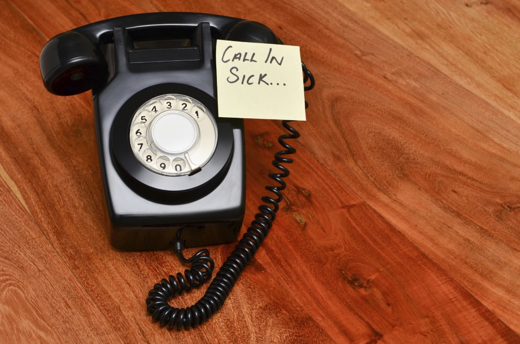 Rotary telephone with a post it reminding you to call in sick Rotary telephone with a post it reminding you to call in sick