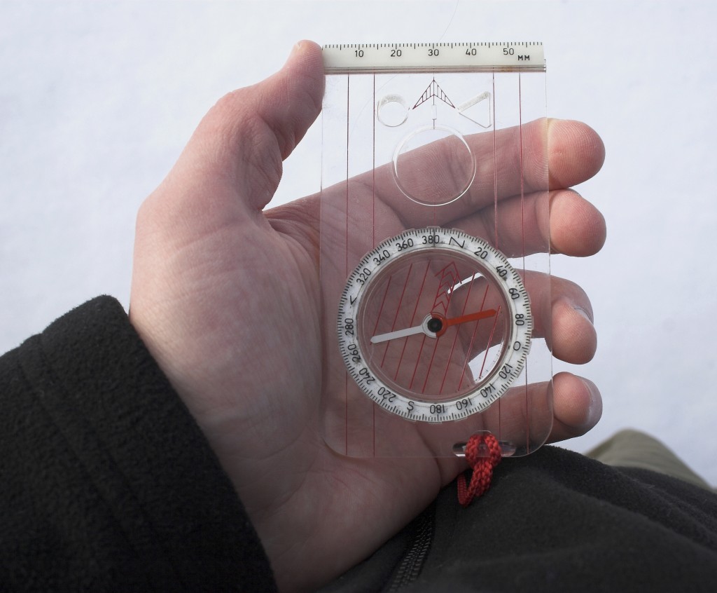 Person holding a compass to take a bearing Person holding a compass to take a bearing