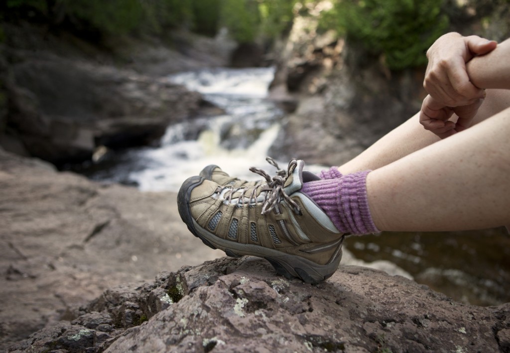 Hiker with boots sitting by a river Hiker with boots sitting by a river