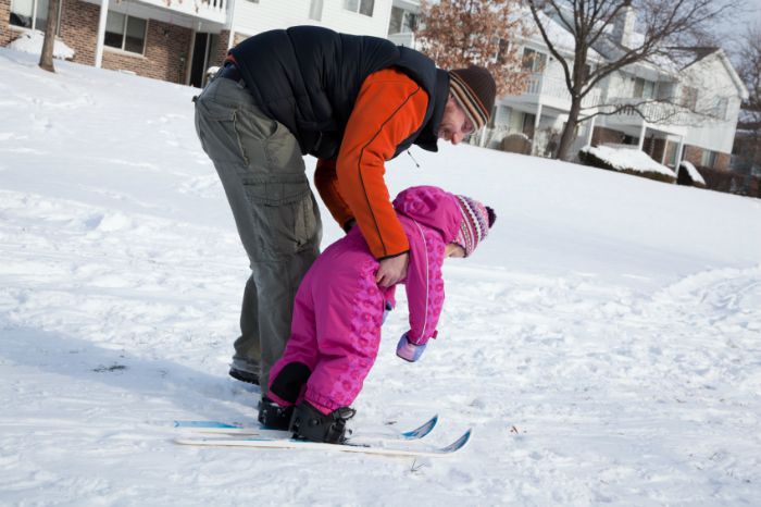 A parent teaching their kid how to ski. A parent teaching their kid how to ski.